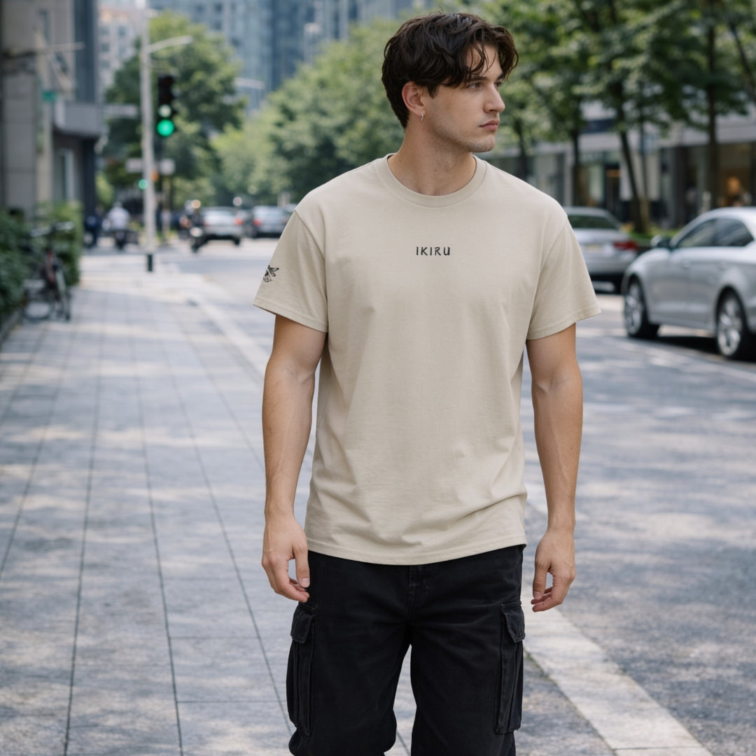Man wearing a beige IKIRU branded t-shirt in a bussing street