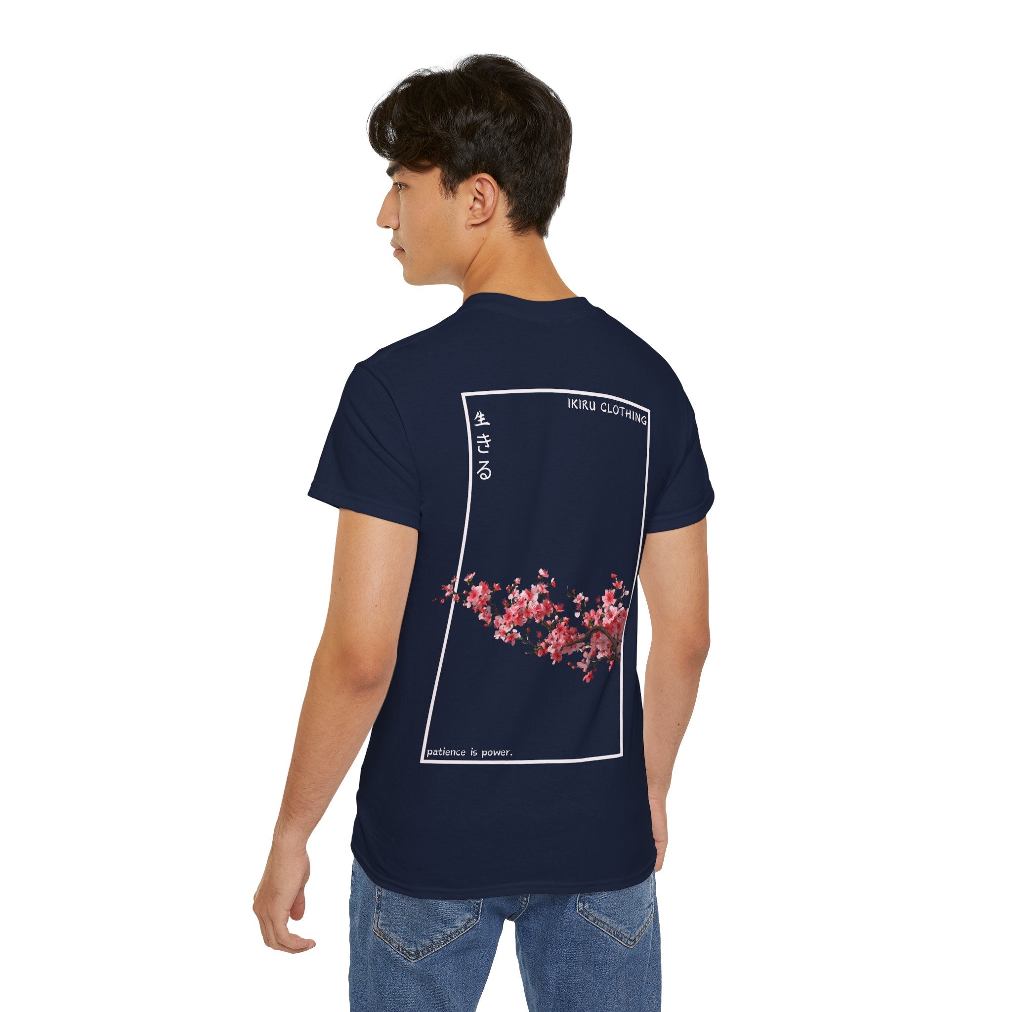 Person wearing a navy t-shirt with cherry blossom design and 'IKIRU CLOTHING' branding on a white background
