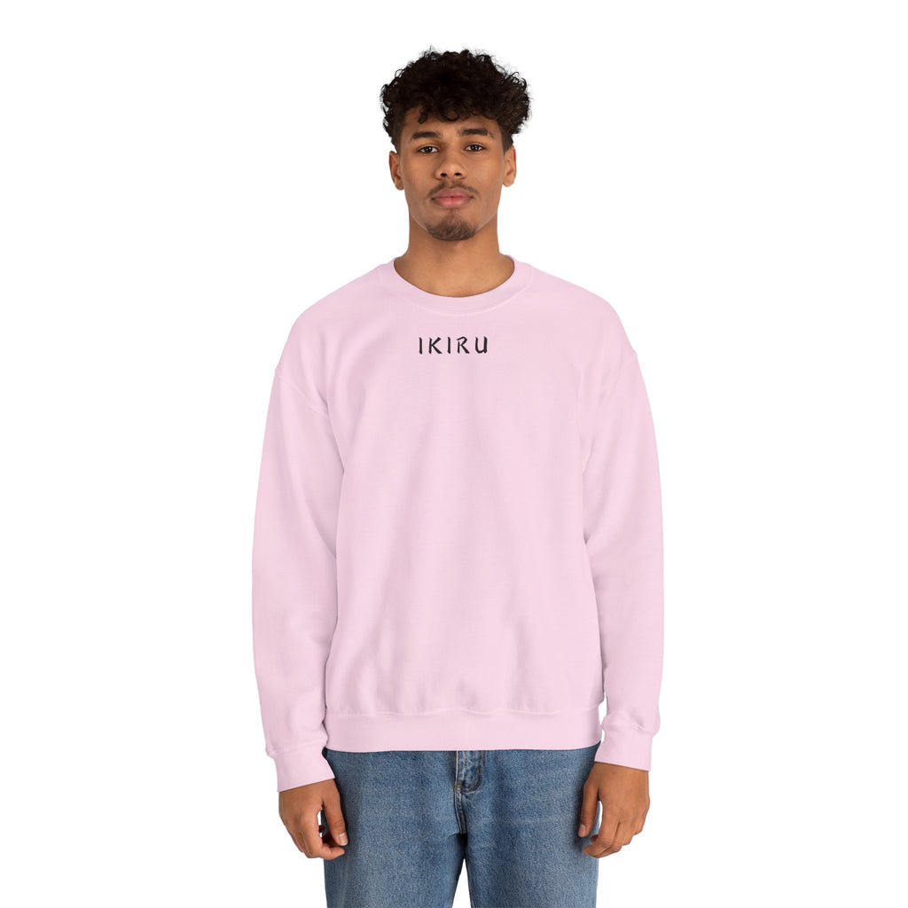 Person wearing a light pink sweatshirt with a small ikiru logo on a white background