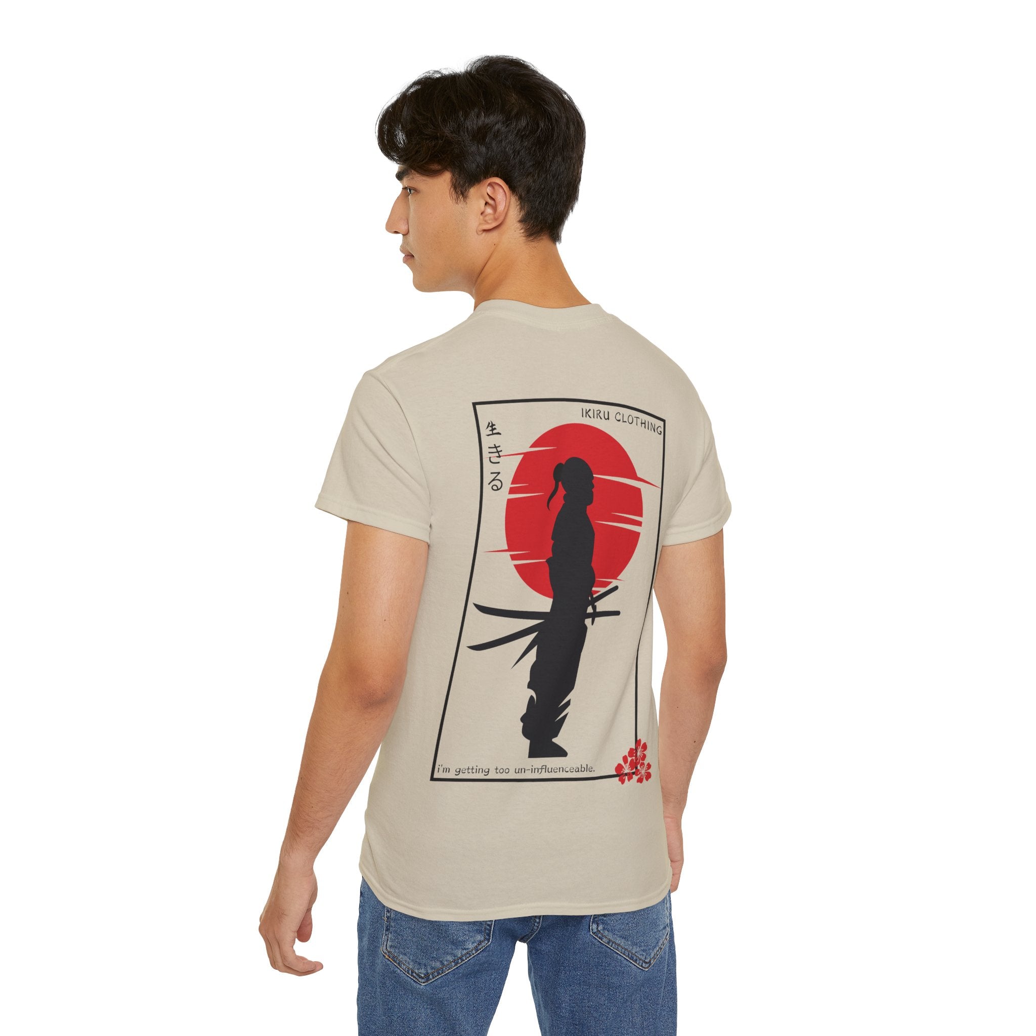Man wearing a beige t-shirt with a graphic design on the back, standing against a white background