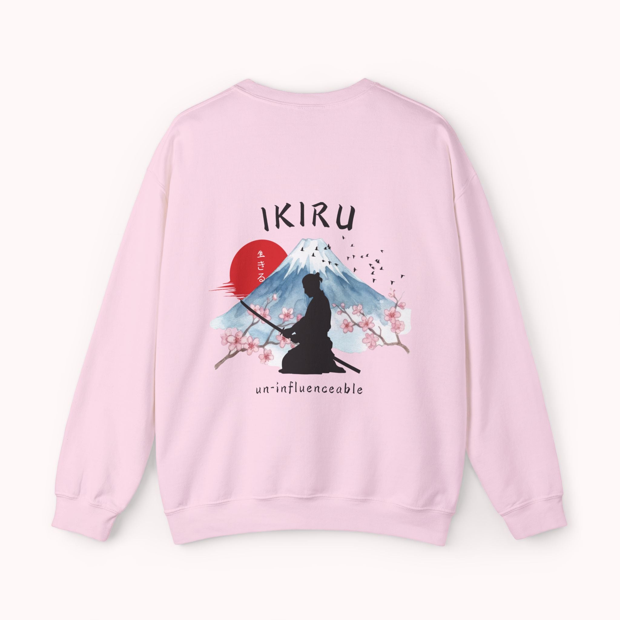 Pink sweater with a mountain, samurai, and blossom tree design on the back saying 'un-influenceable' against a white background