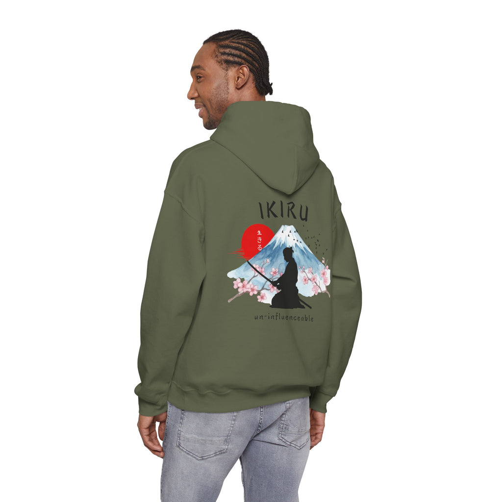 Green hoodie with 'IKIRU' and mountain, samurai, and blossom tree design on the back saying 'un-influenceable' against a white background