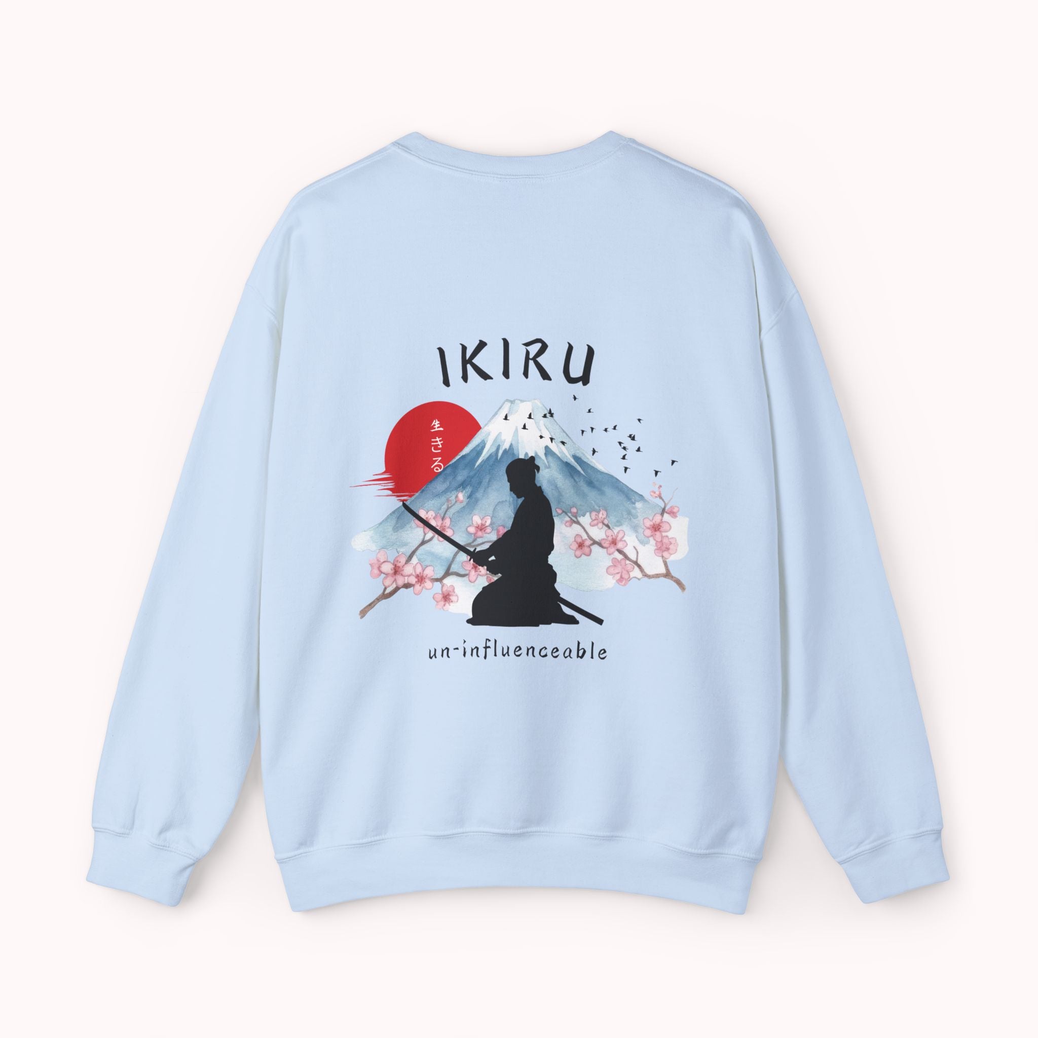 Light blue sweater with a mountain, samurai, and blossom tree design on the back saying 'un-influenceable' against a white background