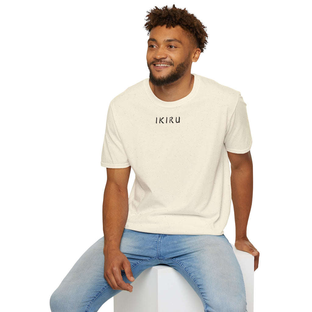 Man wearing a beige t-shirt and blue jeans sitting on a white stool against a white background
