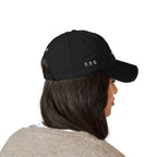 Person wearing a black cap with a logo on a white background