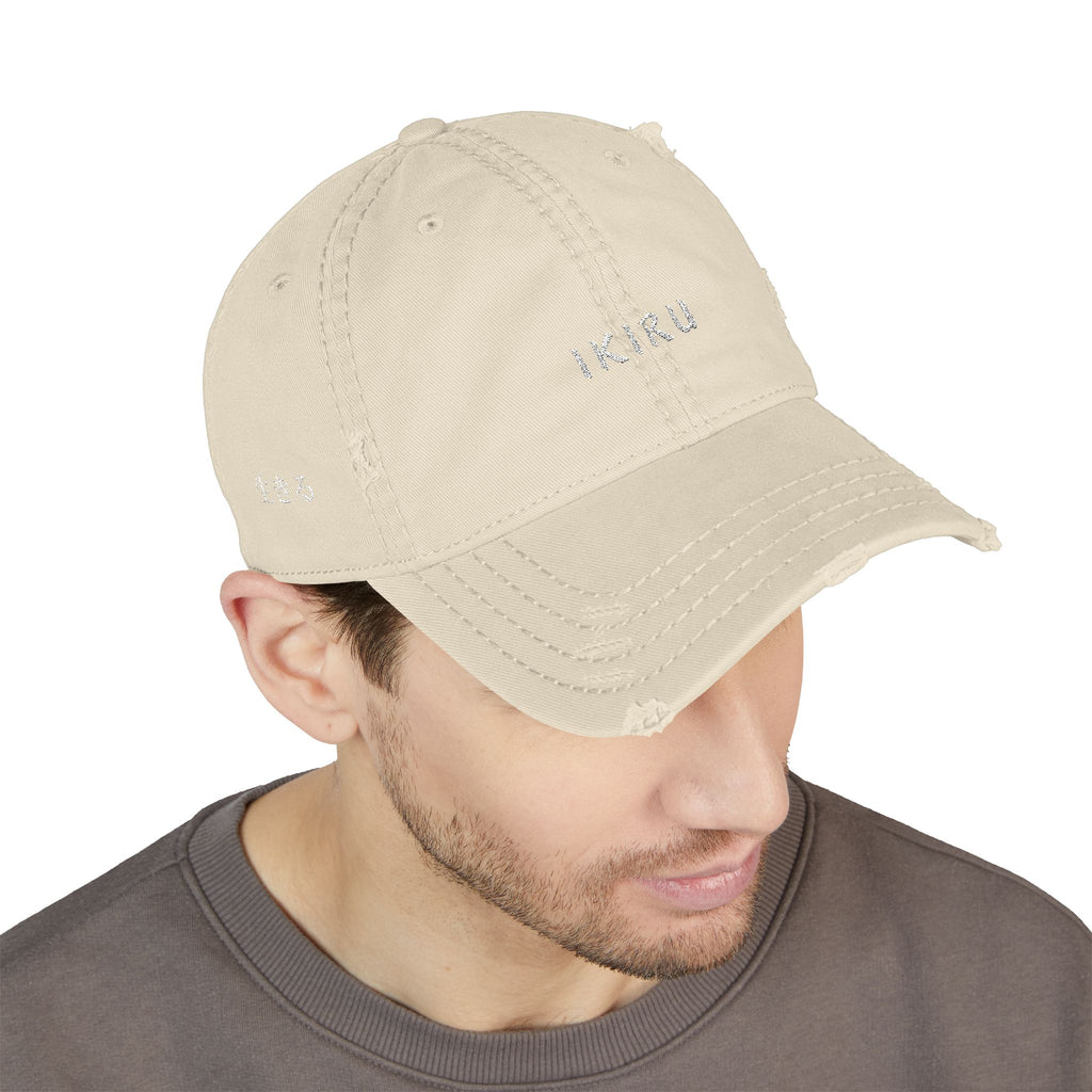 Beige cap with branding worn by a person on a white background