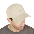 Beige cap with branding worn by a person on a white background