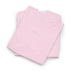 Folded pink shirts with 'IKIRU' embroidery on a white background