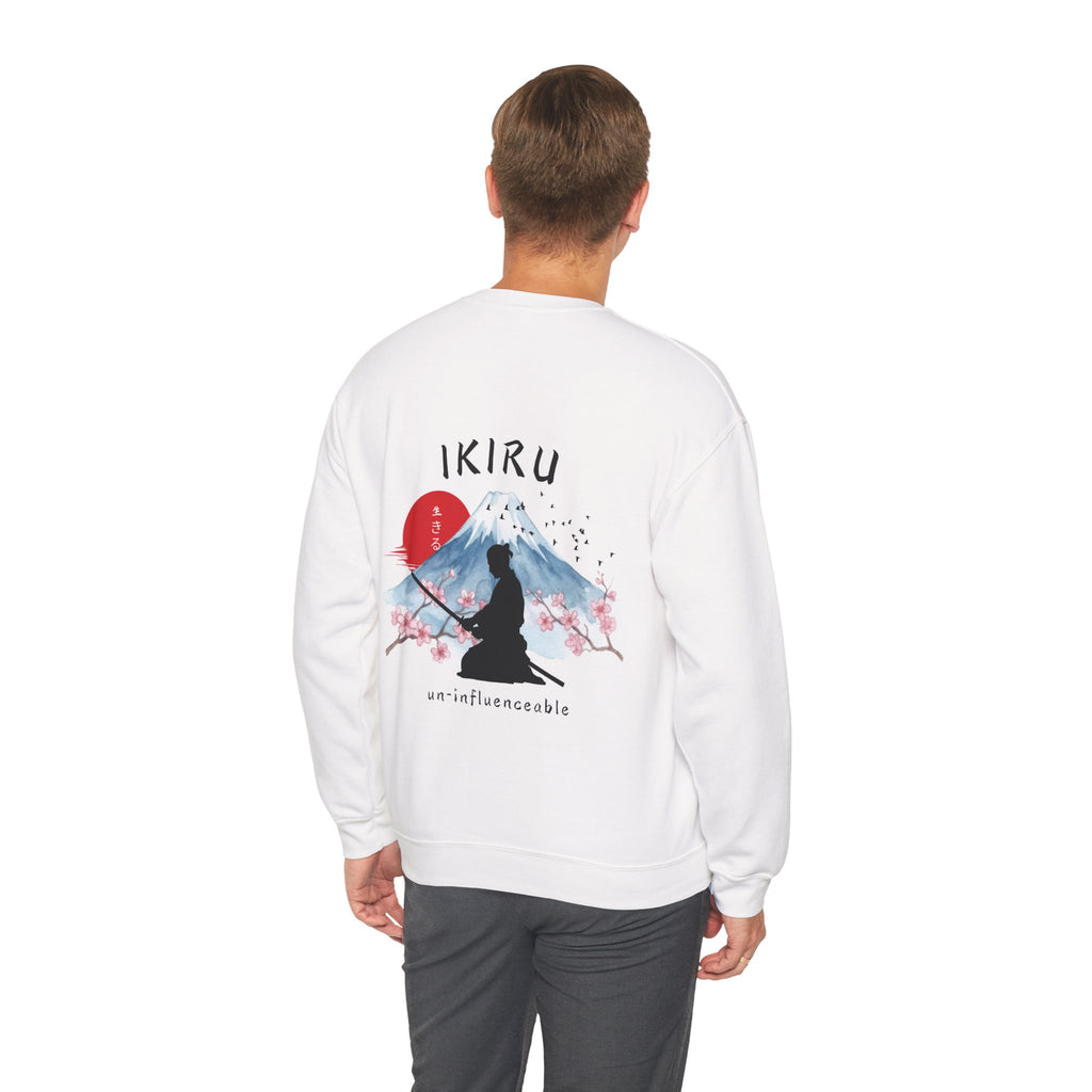Man wearing white sweater with a mountain, samurai, and blossom tree design on the back saying 'un-influenceable' against a white background