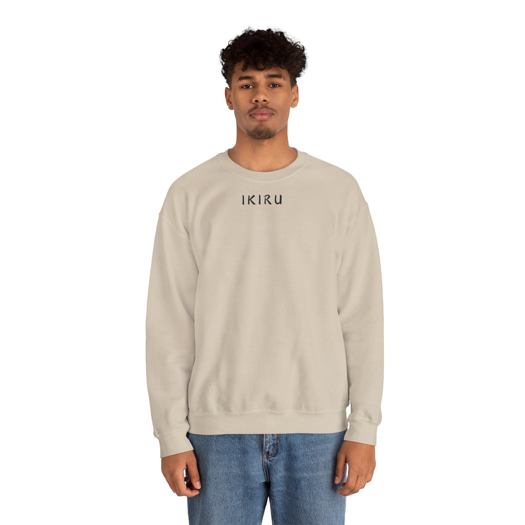 Man wearing a beige sweatshirt with a small ikiru logo on a white background