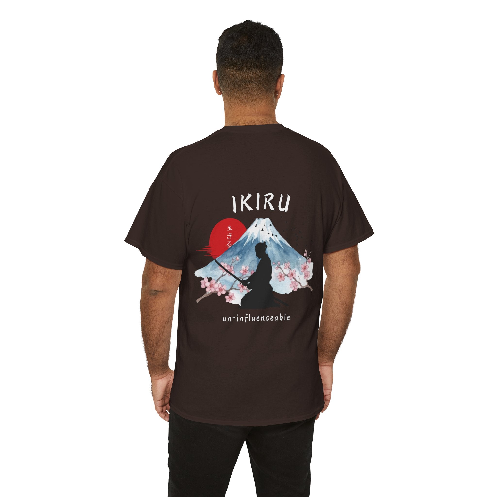 Person wearing a brown t-shirt with Japanese mountain, samurai, blossom and IKIRU on the back on a white background