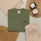 Green t-shirt with 'Not present, I'm alive' text on a neutral background with pants and decor items.