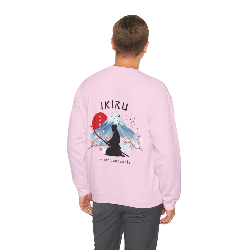 Man wearing pink sweater with a mountain, samurai, and blossom tree design on the back saying 'un-influenceable' against a white background