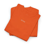 Folded orange shirt with 'IKIRU' branding on a white background