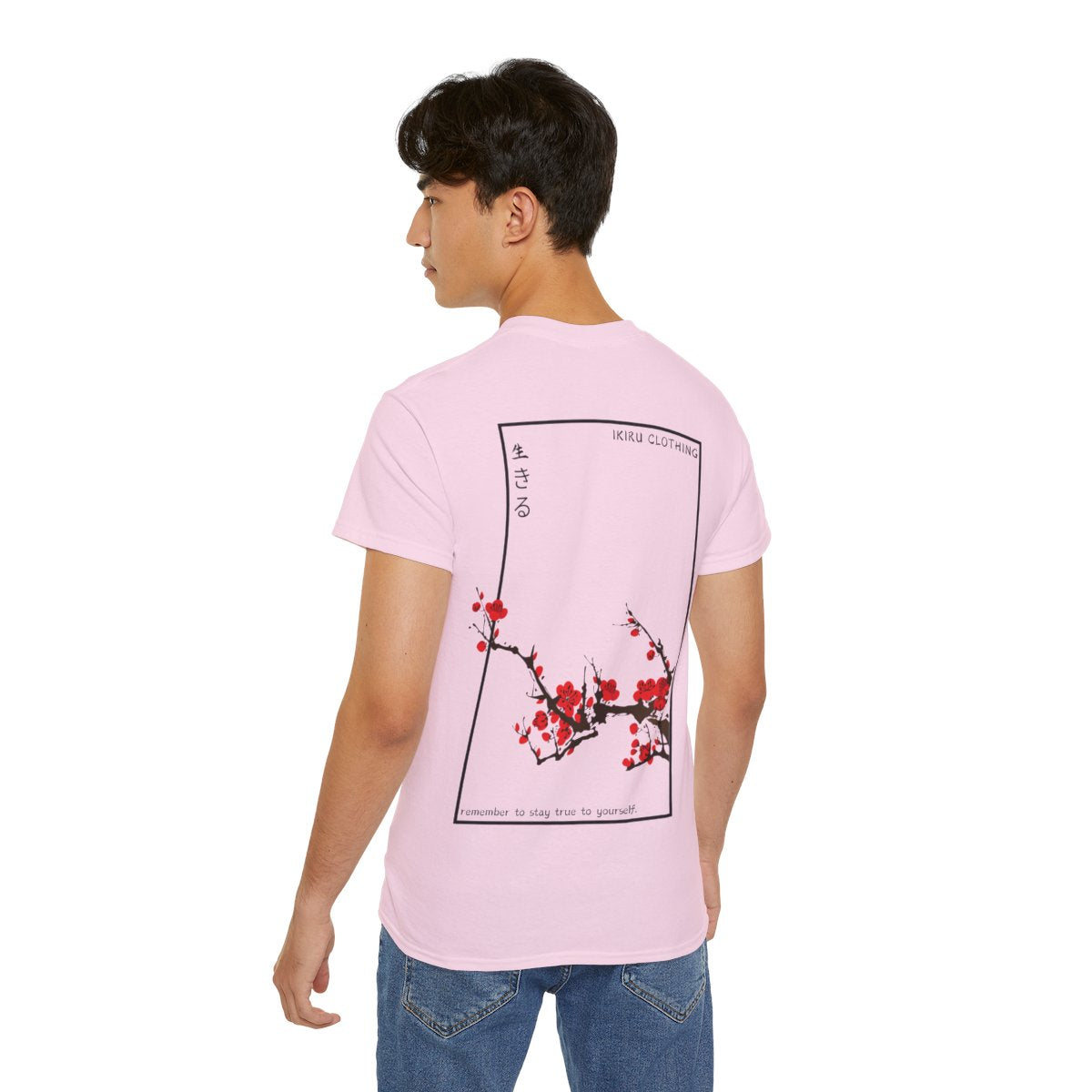 Person wearing a pink t-shirt with Japanese cherry blossom design from 'IKIRU CLOTHING' on a white background