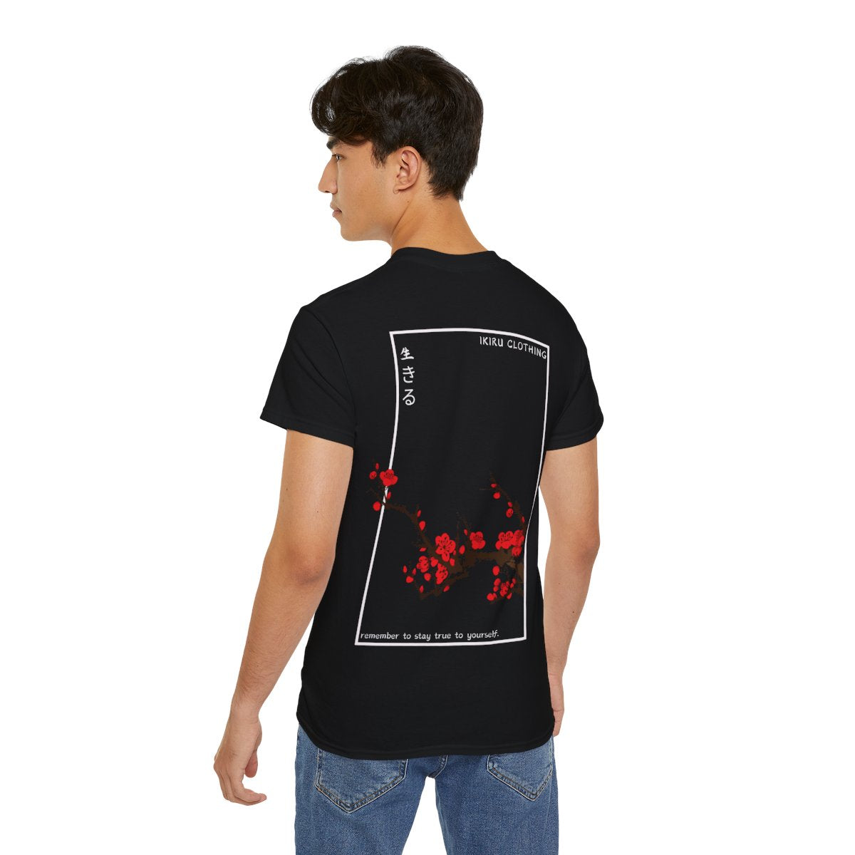 Person wearing a black t-shirt with Japanese cherry blossom design from 'IKIRU CLOTHING' on a white background