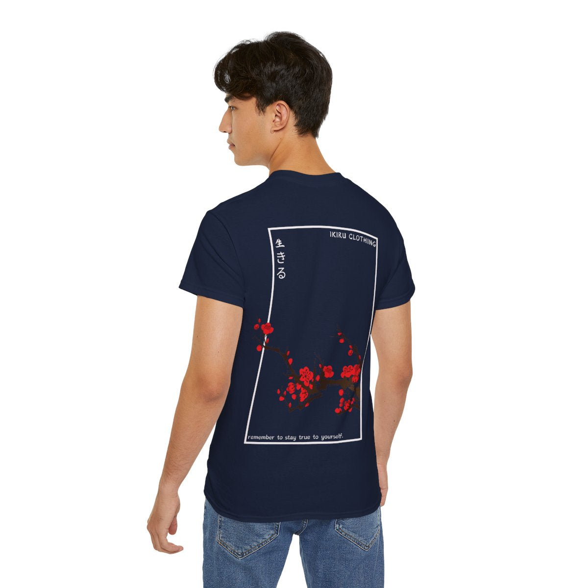 Person wearing a navy t-shirt with Japanese cherry blossom design from 'IKIRU CLOTHING' on a white background
