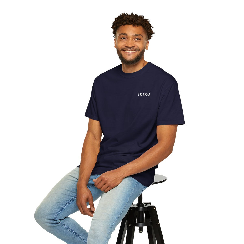 Man wearing a black t-shirt with 'IKIRU' text, sitting on a stool against a white background